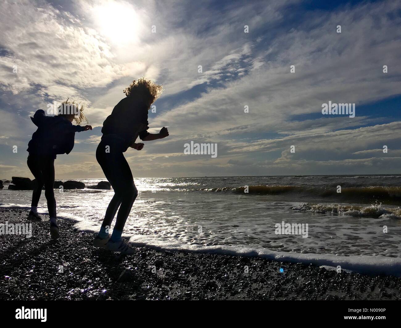 UK Météo : ensoleillé après-midi à Cleveleys dans le Lancashire. In silhouette playing on beach Banque D'Images UK Météo : ensoleillé après-midi à Cleveleys dans le Lancashire. In silhouette playing on beach Banque D'Images