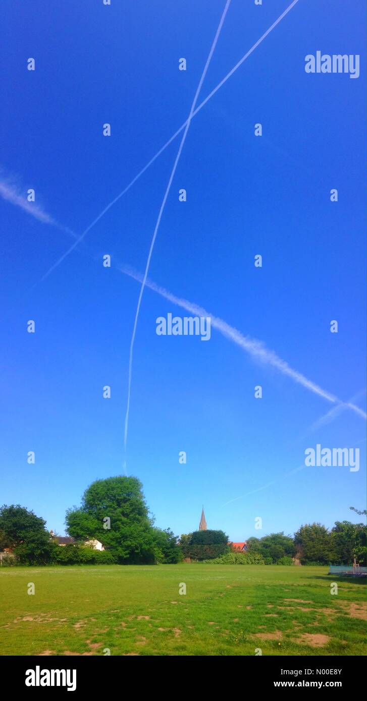 Royaume-uni - Un ciel bleu avec des traînées de vapeur d'avions passant plus de lecture à ce qui semble être une chaude journée. Banque D'Images