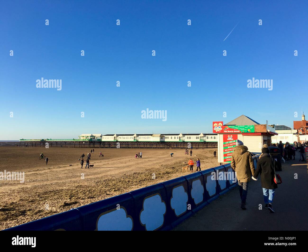 UK Météo : ensoleillé à Lytham St Annes, Lancashire. Les personnes bénéficiant de l'un ciel bleu dans un ciel ensoleillé mais froid froide journée sur St Annes beach. Banque D'Images UK Météo : ensoleillé à Lytham St Annes, Lancashire. Les personnes bénéficiant de l'un ciel bleu dans un ciel ensoleillé mais froid froide journée sur St Annes beach. Banque D'Images