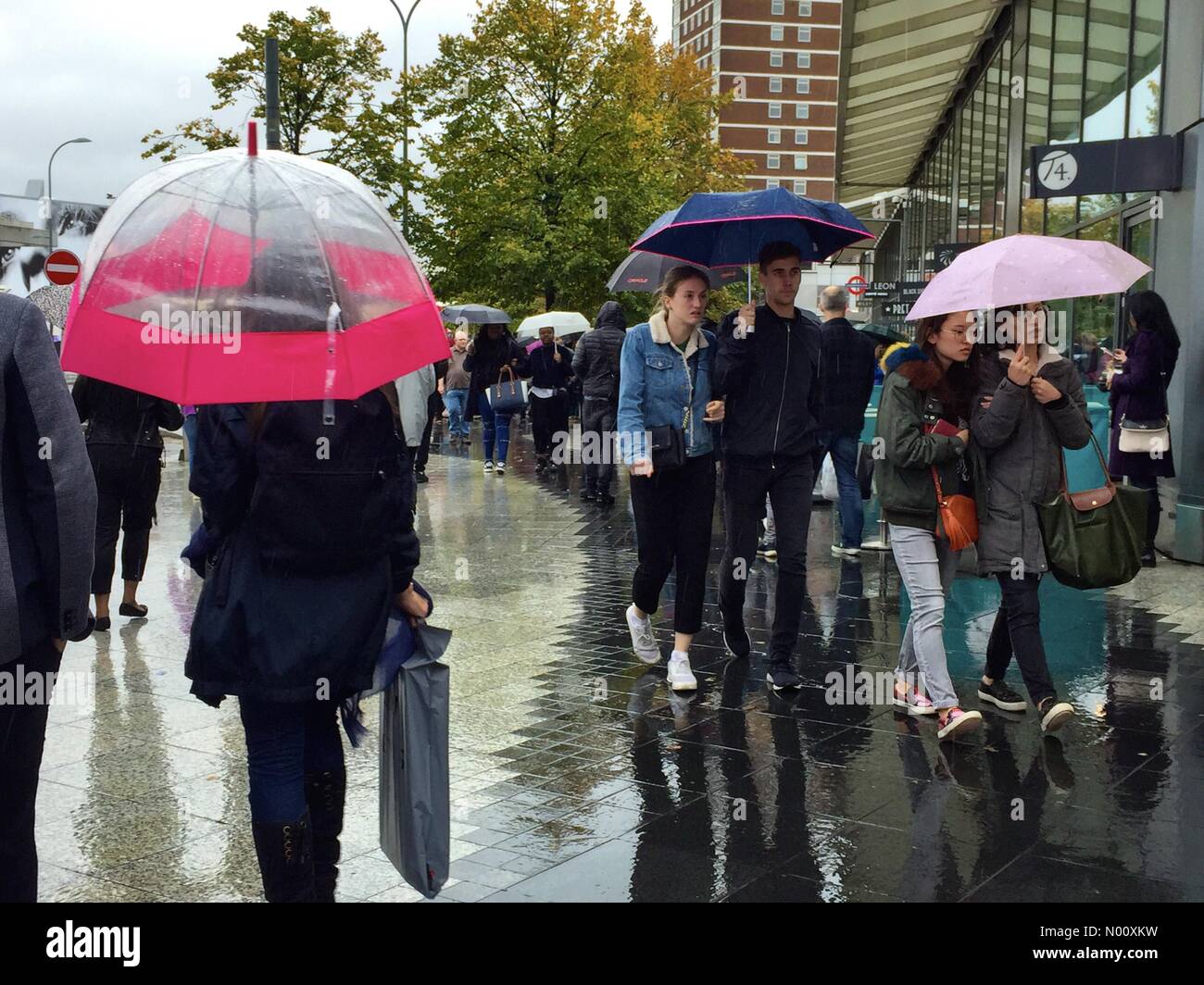 Météo France : Les gens utilisent des parapluies à l'abri de la pluie dans la région de Shepherd's Bush, Londres. Banque D'Images