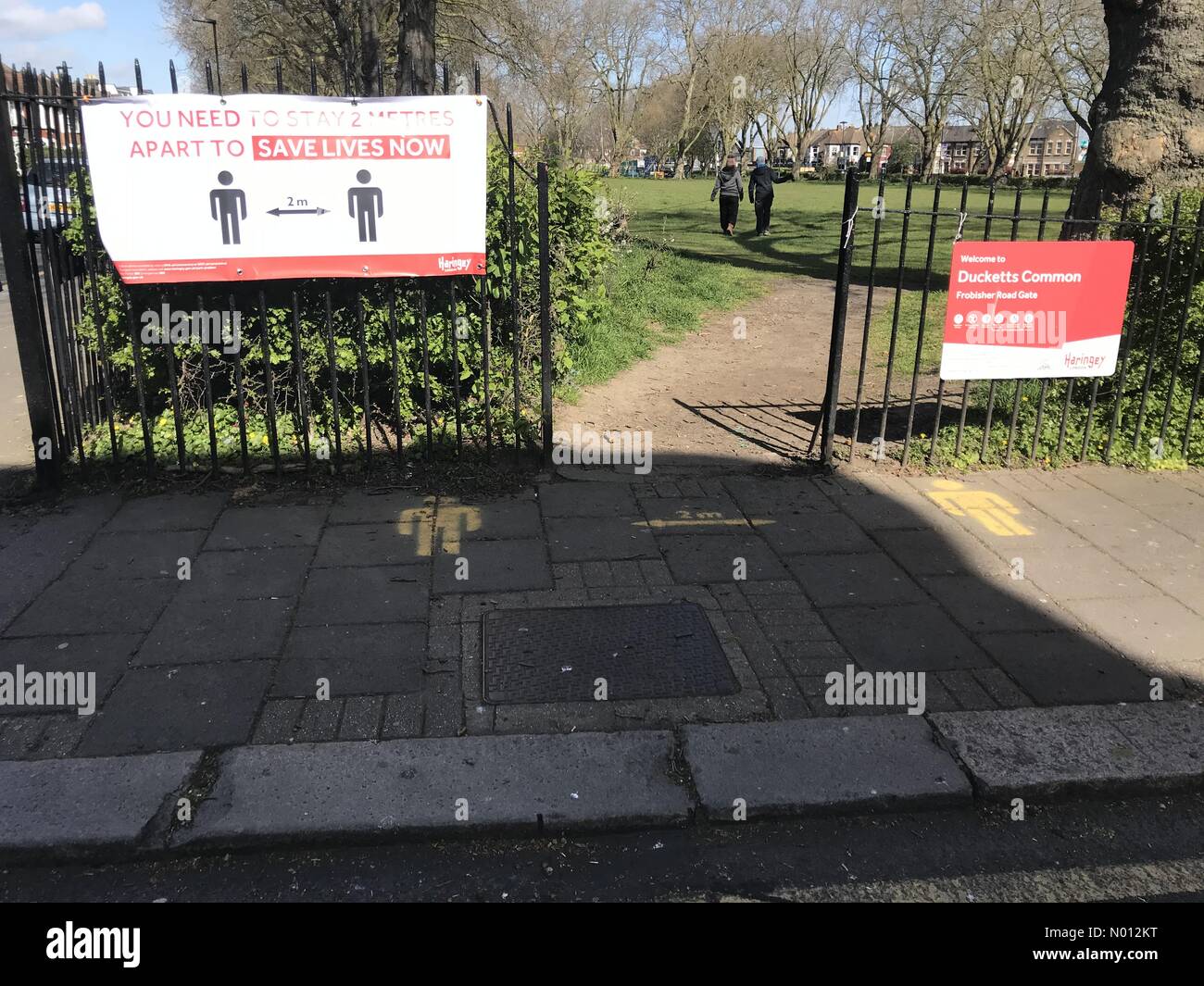 Deux marcheurs pour chiens profitent du temps ensoleillé au milieu d'un maintien continu à Turnpike Lane, nord de Londres crédit: Paul Swinney/StockimoNews/Alay Live News Banque D'Images