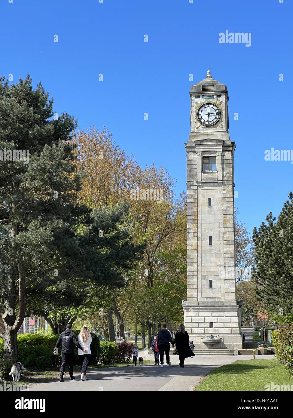 Blackpool, Lancashire, Royaume-Uni. 28 avril 2024. Météo Royaume-Uni : ensoleillé à Blackpool. Les gens marchent dans le parc pour une journée ensoleillée à Stanley Park, Blackpool. Tour de l'horloge Cocker. Crédit : Lancashire images/StockimoNews/Alamy Live News Banque D'Images