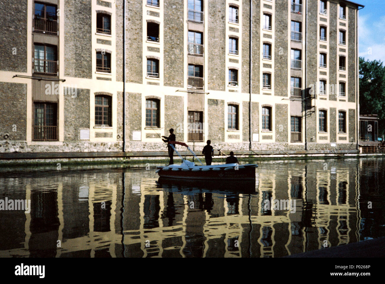 Les pêcheurs d'un petit bateau de pêche dans le bassin de La Villette sur le Canal de l'Ourcq, Paris , France, Europe. Banque D'Images