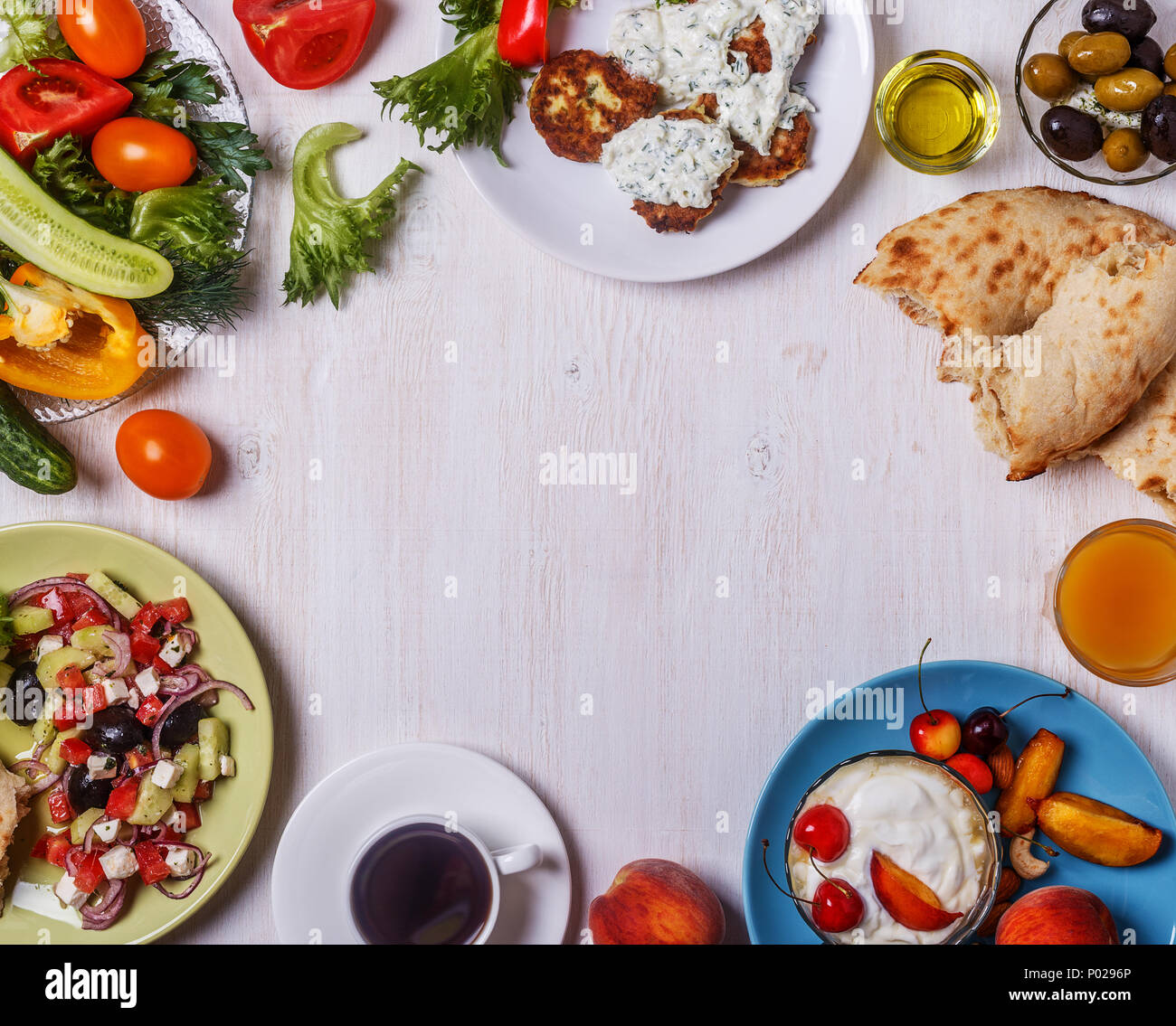 Apéritifs grecs - beignets de courgette avec sauce tzatziki, salade grecque, yaourt aux fruits et noix, olives, légumes et fines herbes, vue d'en haut, c Banque D'Images