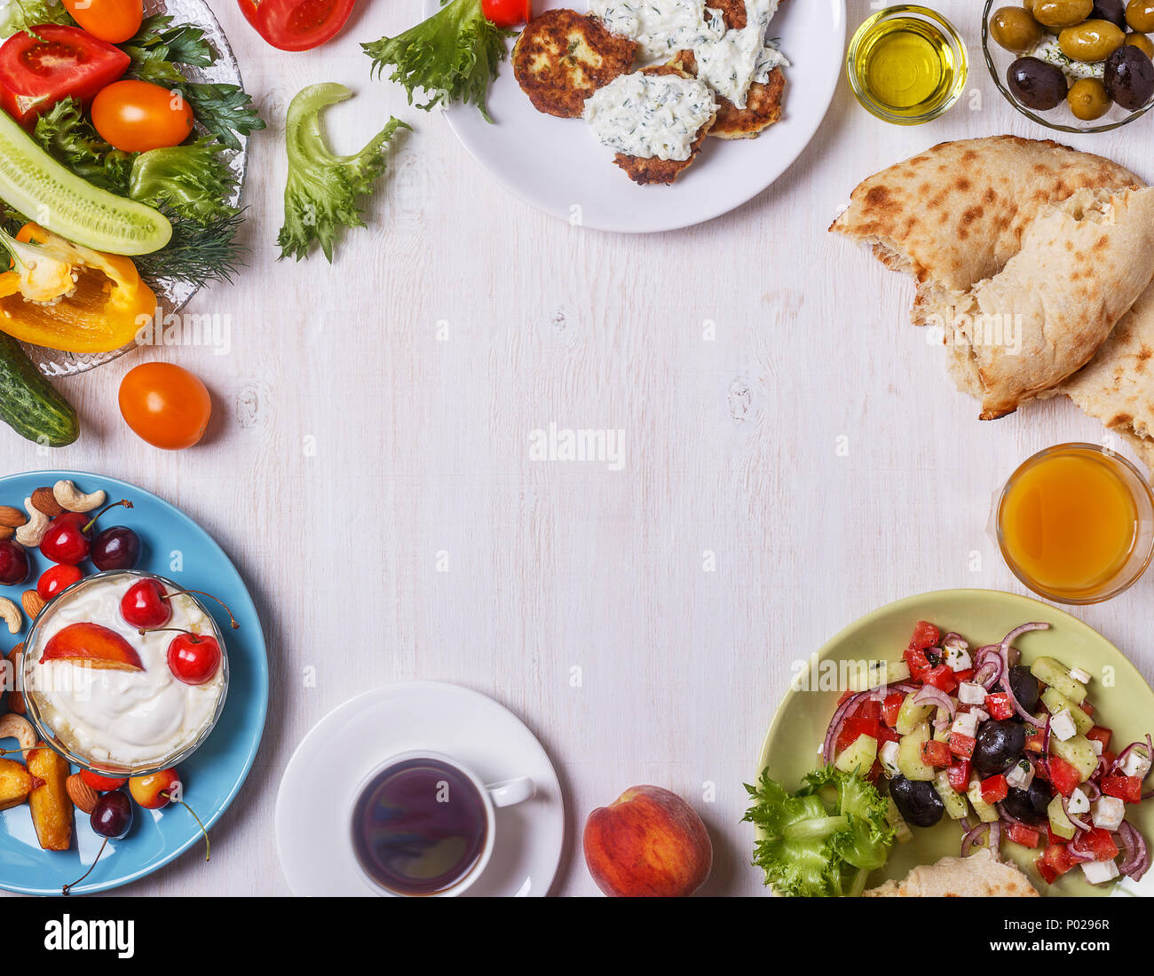Apéritifs grecs - beignets de courgette avec sauce tzatziki, salade grecque, yaourt aux fruits et noix, olives, légumes et herbes vue supérieure, co Banque D'Images