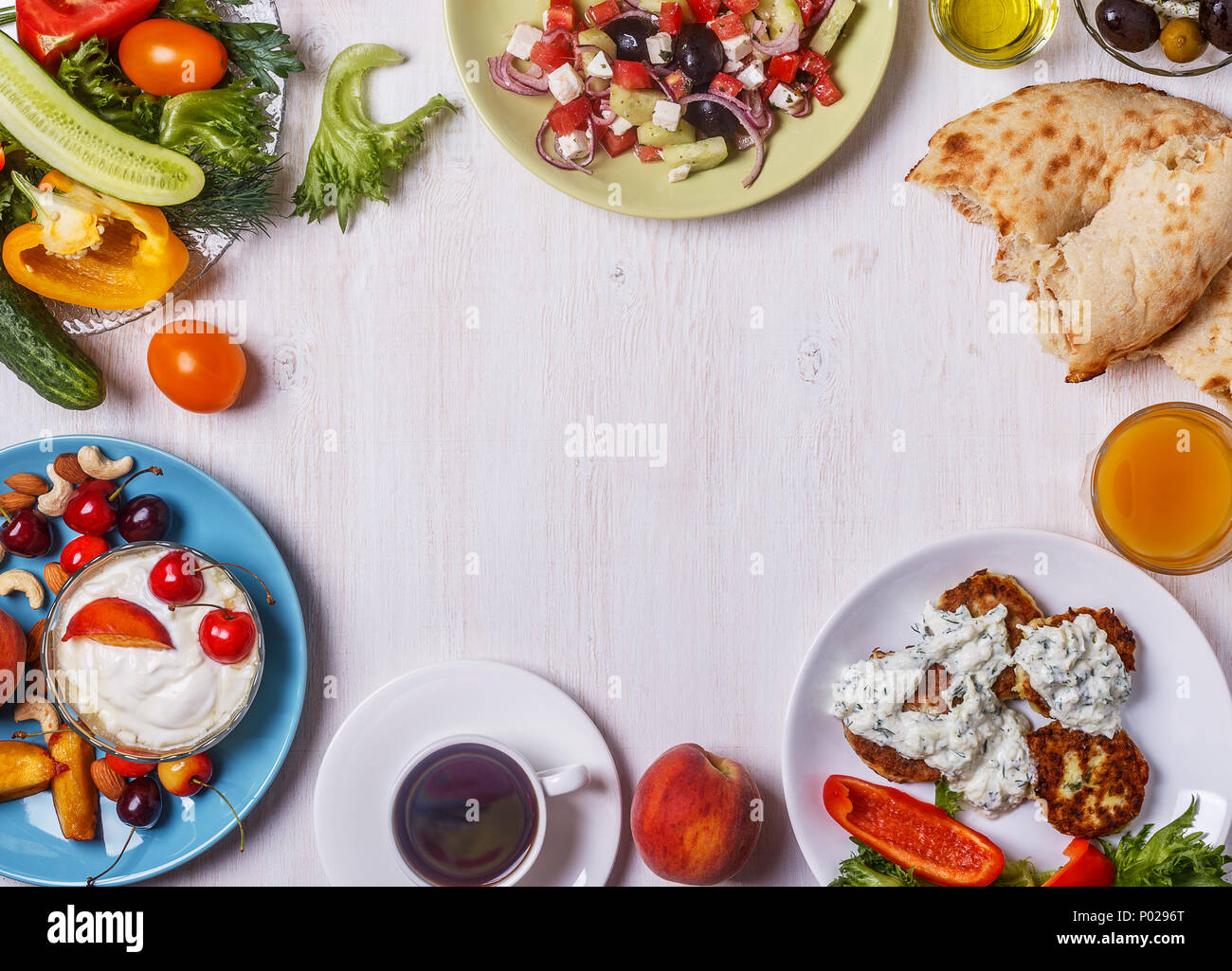 Apéritifs grecs - beignets de courgette avec sauce tzatziki, salade grecque, yaourt aux fruits et noix, olives, légumes et fines herbes, vue d'en haut, c Banque D'Images