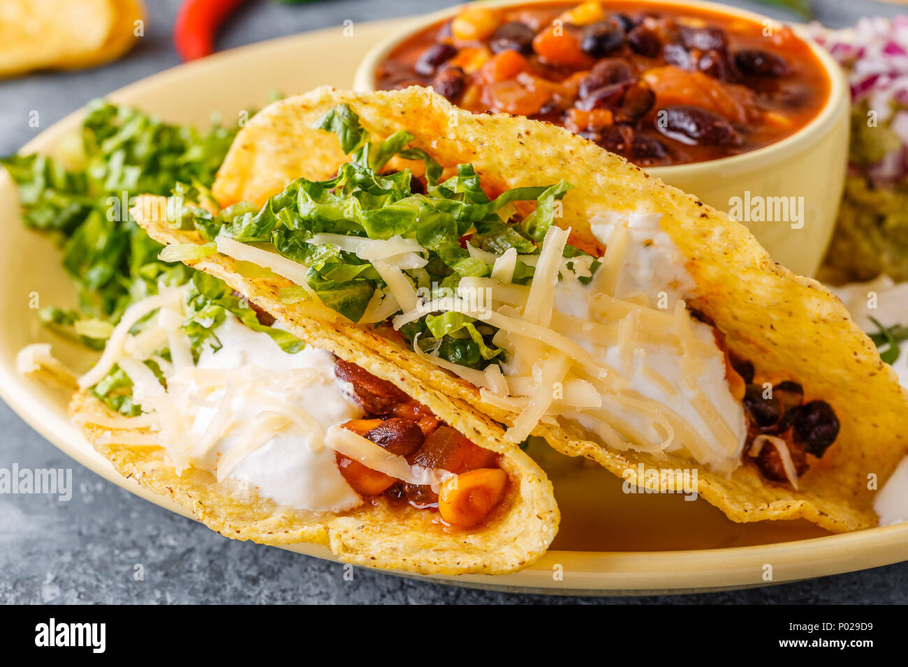 Les tacos avec chili con carne, salade, fromage et crème sure, selective focus. Banque D'Images