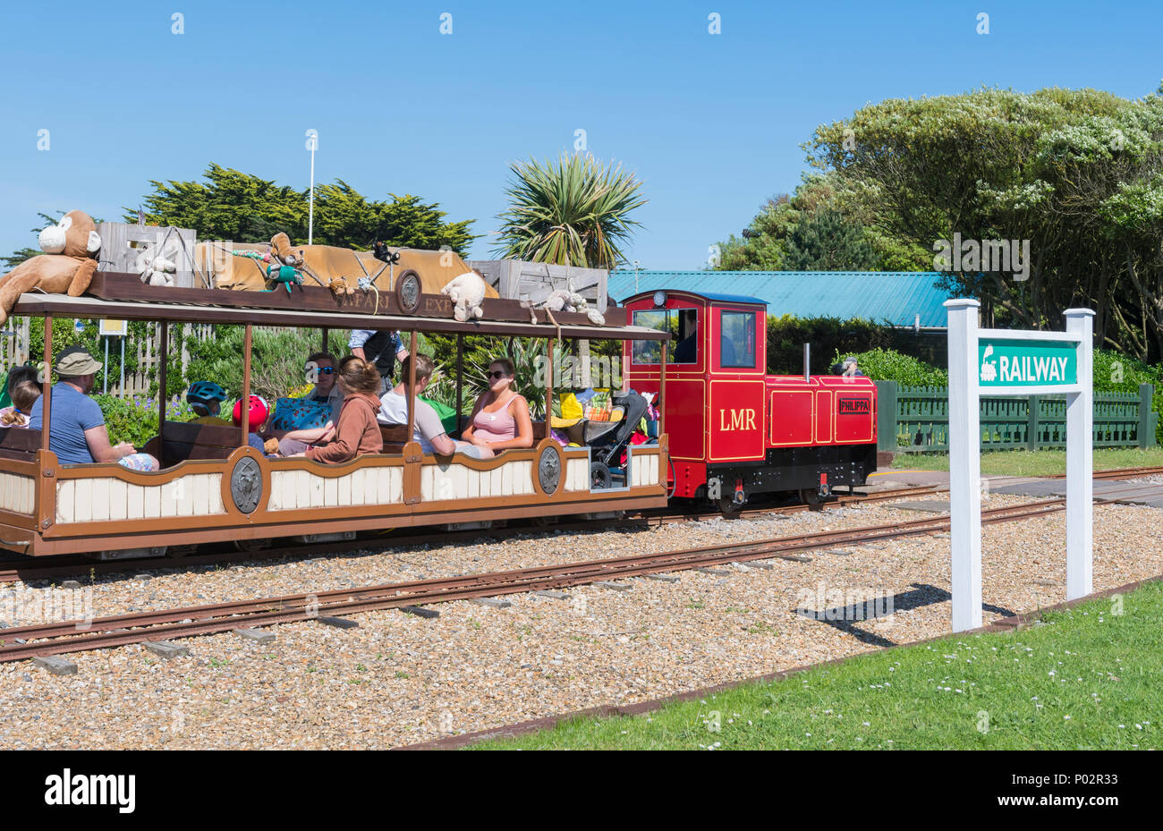 Petite locomotive et des gens à cheval sur le chemin de fer miniature à Arundel Norfolk Gardens, Littlehampton, West Sussex, Angleterre, Royaume-Uni. Banque D'Images