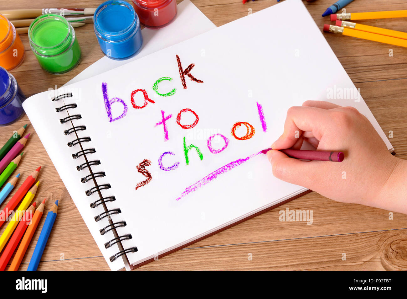 L'auteur des paroles de l'enfant Retour à l'école sur un ordinateur  portable blanc plié avec diverses peintures, crayons et stylos sur un  bureau de l'école Photo Stock - Alamy