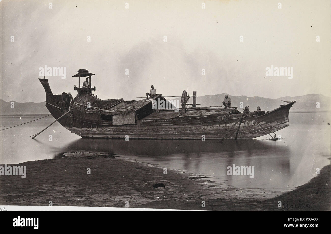 . Photographie avec un vue d'un faisceau-zat laung paddy ou bateau amarré sur le côté de la rivière Irrawaddy, prises par J. Jackson en c.1868, partie d'un album de 43 vues de la Birmanie (Myanmar) à partir de la Collection Sladen. La laung-zat est un bateau traditionnel de la rivière birmane et a été utilisé pour le transport du riz à Rangoon (Yangon). Au 19e siècle, le riz était la principale production agricole récolte et sa plus grande exportation. Le profil distinctif du bateau est clairement montré : une coque longue et étroite, avec une haute et basse, stern guindeau balayés par le bas. À l'extrémité arrière du barreur est assis sous un abri sur un siège surélevé . A B Banque D'Images