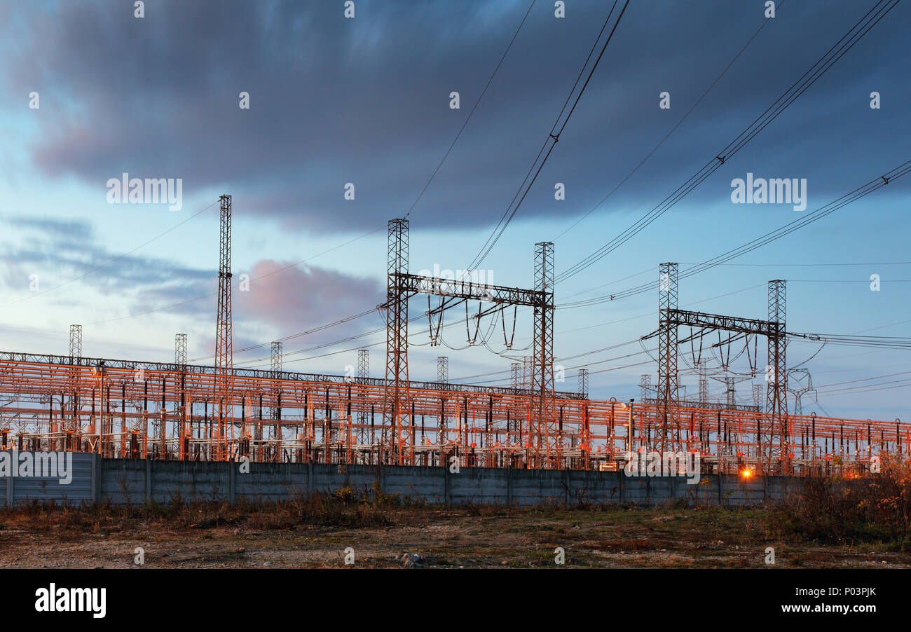 Pylône de transport d'électricité silhouetté contre le ciel bleu au crépuscule Banque D'Images