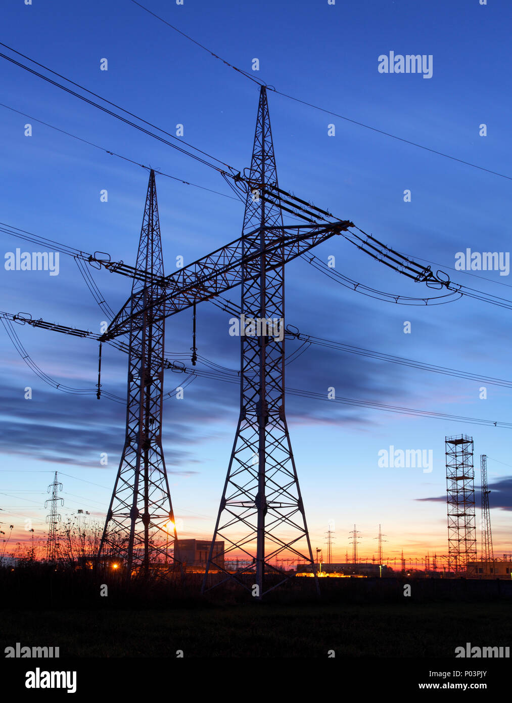 Pylône de transport d'électricité silhouetté contre le ciel bleu au crépuscule Banque D'Images