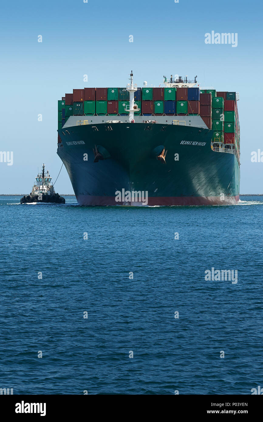 Le porte-conteneurs, SEAMAX NEW HAVEN, guidé par des remorqueurs du tracteur, entre dans le chenal principal de Los Angeles dans le Port de Los Angeles, Californie, USA. Banque D'Images