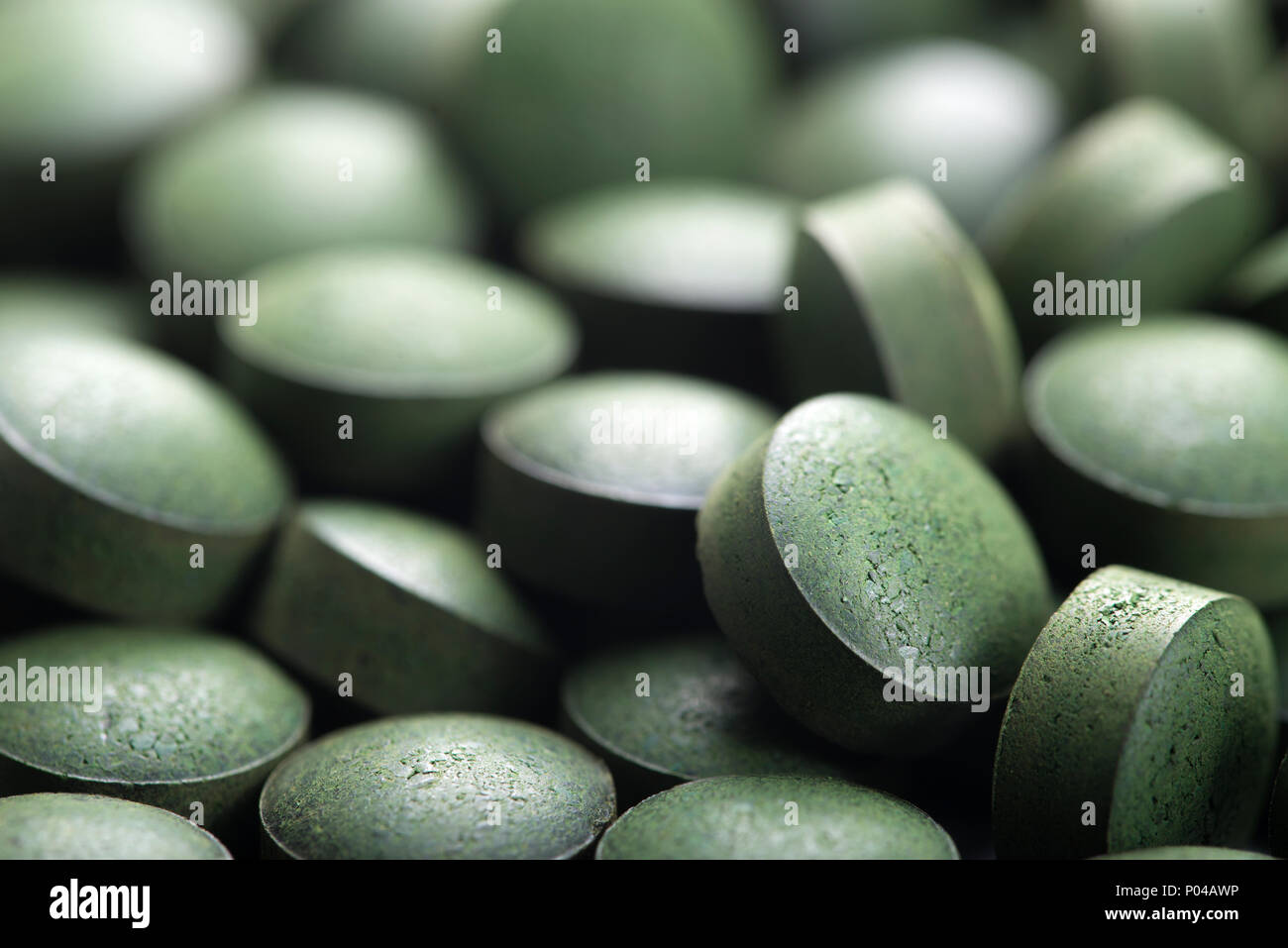 Algues bleu-vert. Close up de matière organique naturelle la spiruline comprimés avec l'accent à l'avant-plan et de l'effet de flou Banque D'Images