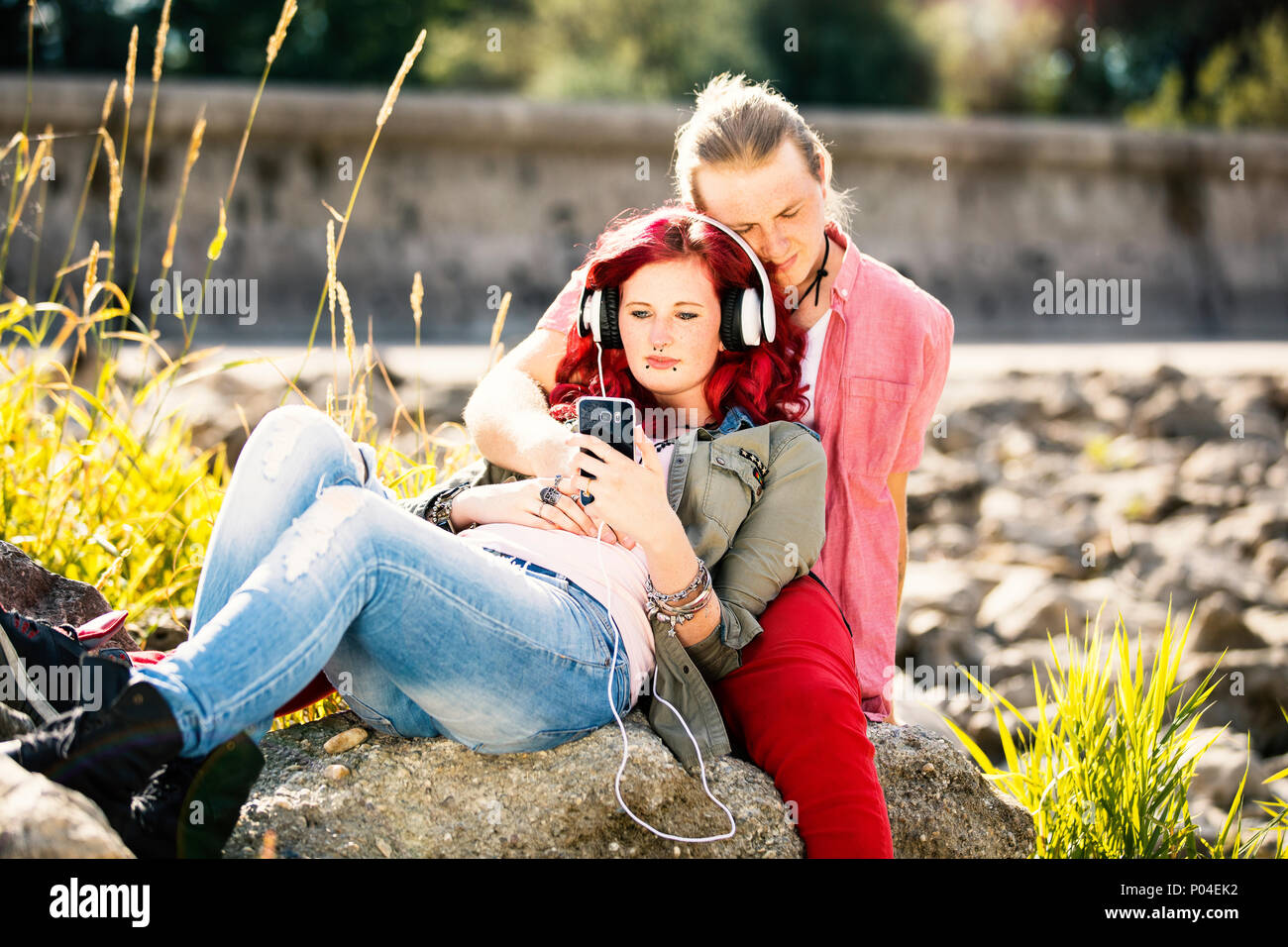Jeune couple amoureux avec des Tatouages et piercings profitant du temps ensemble dans la nature au bord de la rivière Banque D'Images