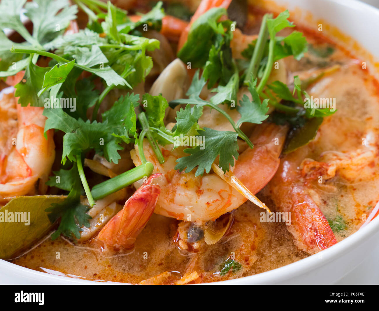 Tom Yam kung, la soupe aigre traditionnel thaï aux crevettes et champignons, garni de coriandre. La photo montre la version rouge de la soupe, faite d'esprit Banque D'Images