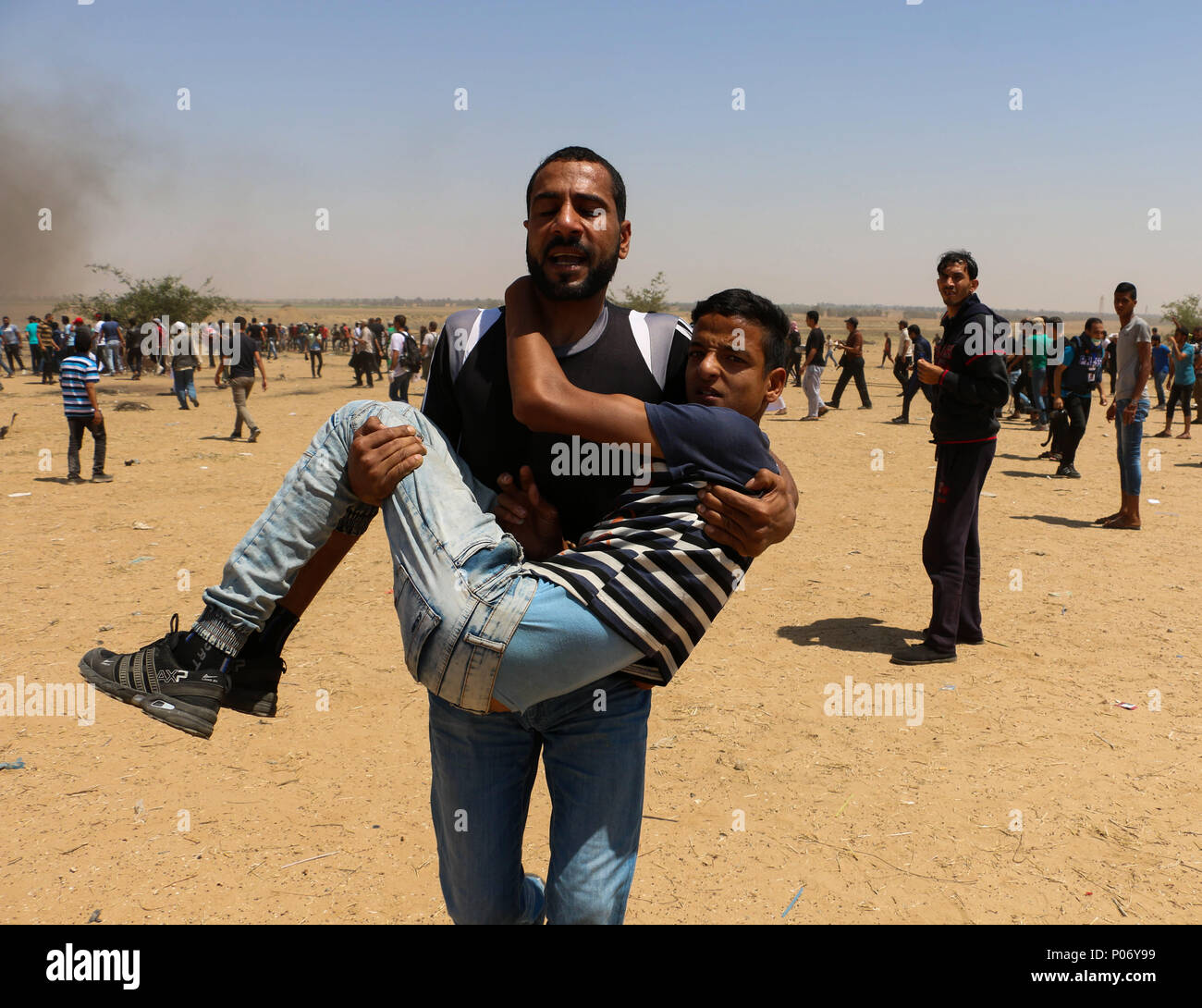 Gaza, la Palestine, le 8 juin, 2018 - des manifestants palestiniens sont blessés lors d'affrontements avec des soldats israéliens au cours d'une marche de protestation de retour sur la frontière Gaza-Israel, à l'est de la ville au sud de la bande de Gaza de Khan Younis. Des milliers de manifestants ont rejoint le Vendredi Mars dans cinq lieux différents près de la frontière israélienne sur la 11e fois consécutive vendredi's ''grande marche du retour'' les manifestations qui ont débuté le 30 mars. Banque D'Images