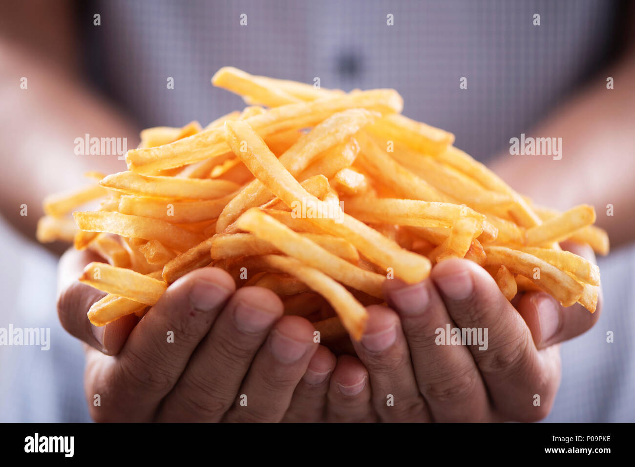Libre d'un jeune homme de race blanche avec une bande d'appétissants frites dans ses mains Banque D'Images