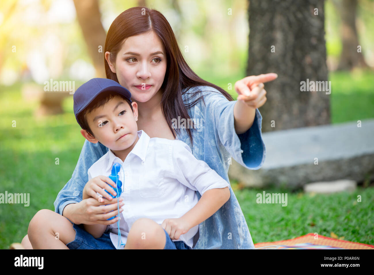 Belle asiatique mère jouant avec son joli fils main pointant à l'avenir à la concept. Banque D'Images