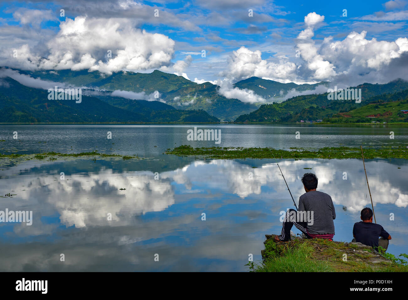 Deux hommes pêchant au lac Fewa à Pokhara, au Népal Banque D'Images