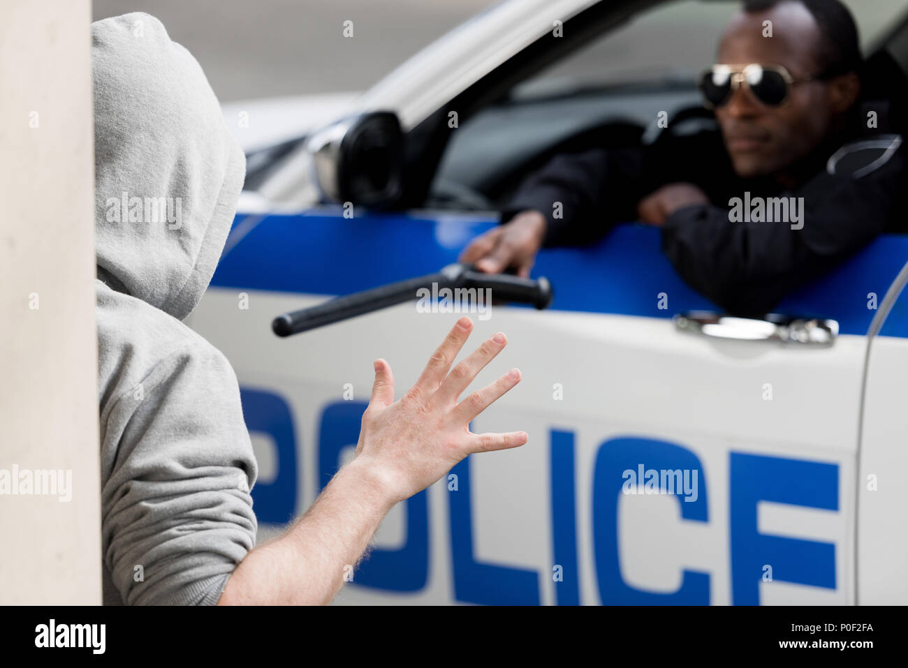 Agent de police sur le site de fenêtre de voiture et en montrant l'homme à capuchon avec la police bat Banque D'Images