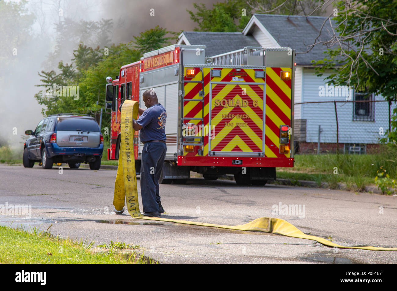 Detroit, Michigan - Un pompier gère un tuyau d'incendie à un incendie du bâtiment sur la partie est de Detroit. Banque D'Images