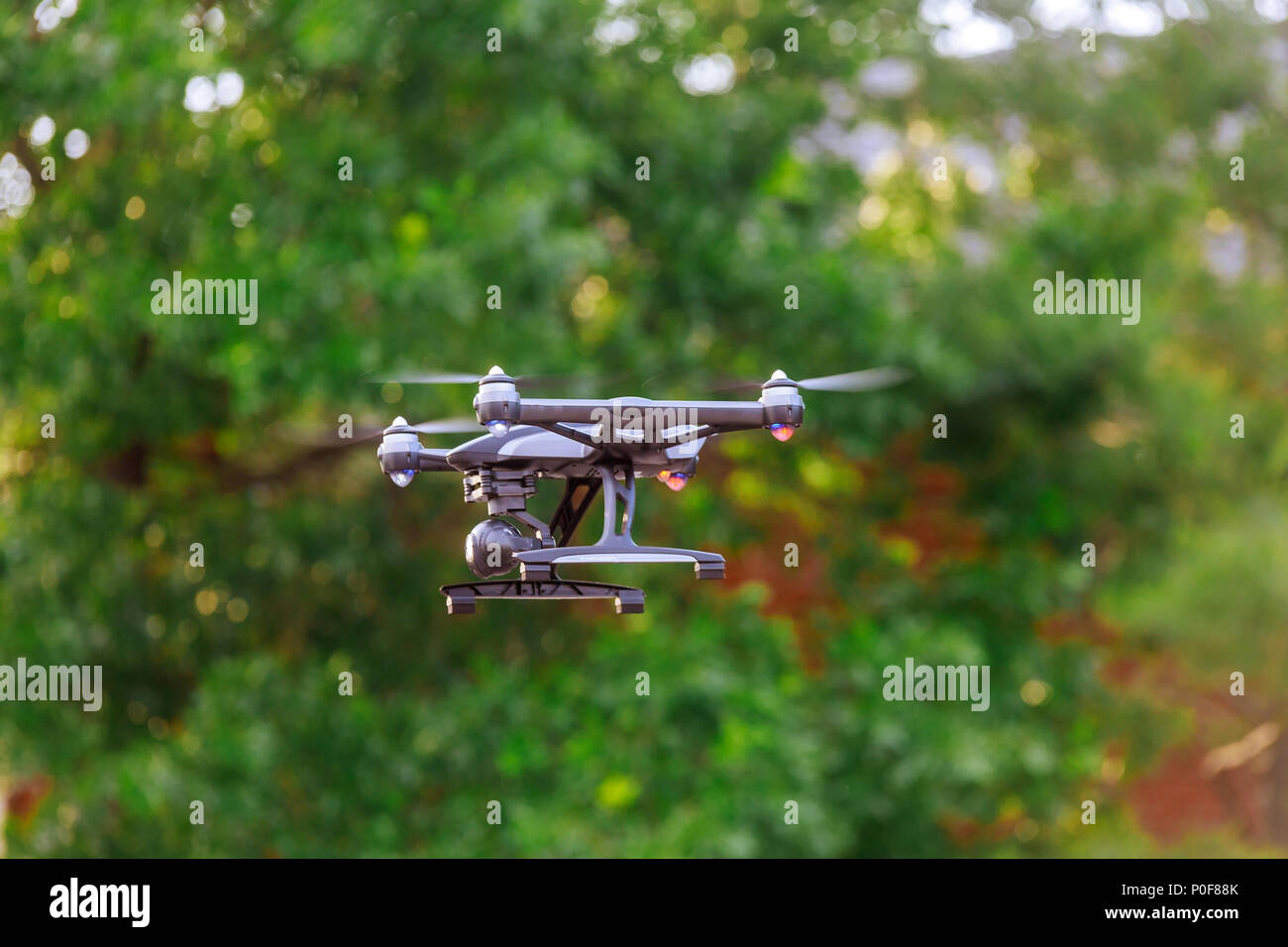 Drone avec caméra de cinéma professionnel survolant un parc d'été Photo  Stock - Alamy