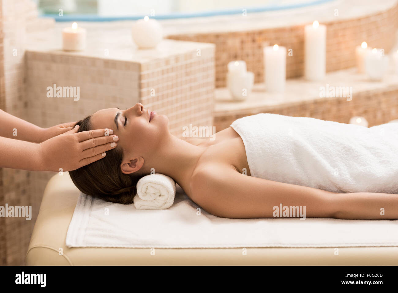 Jolie femme se détendre et s'massage de la tête dans un salon de massage Banque D'Images