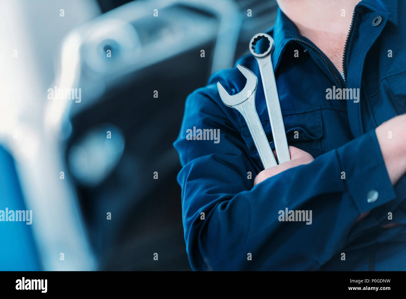 Libre tourné d'un automechanic dans des combinaisons clé clé de retenue et Banque D'Images