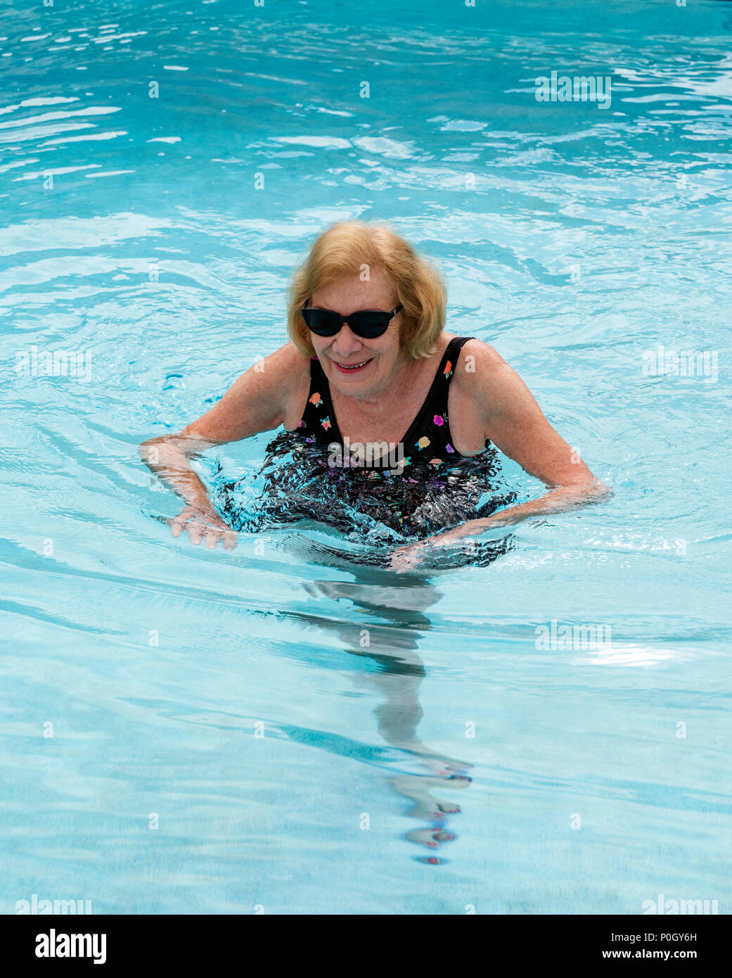 Femme hauts femme exerçant dans une piscine extérieure ; le centre-sud de la Floride, USA Banque D'Images