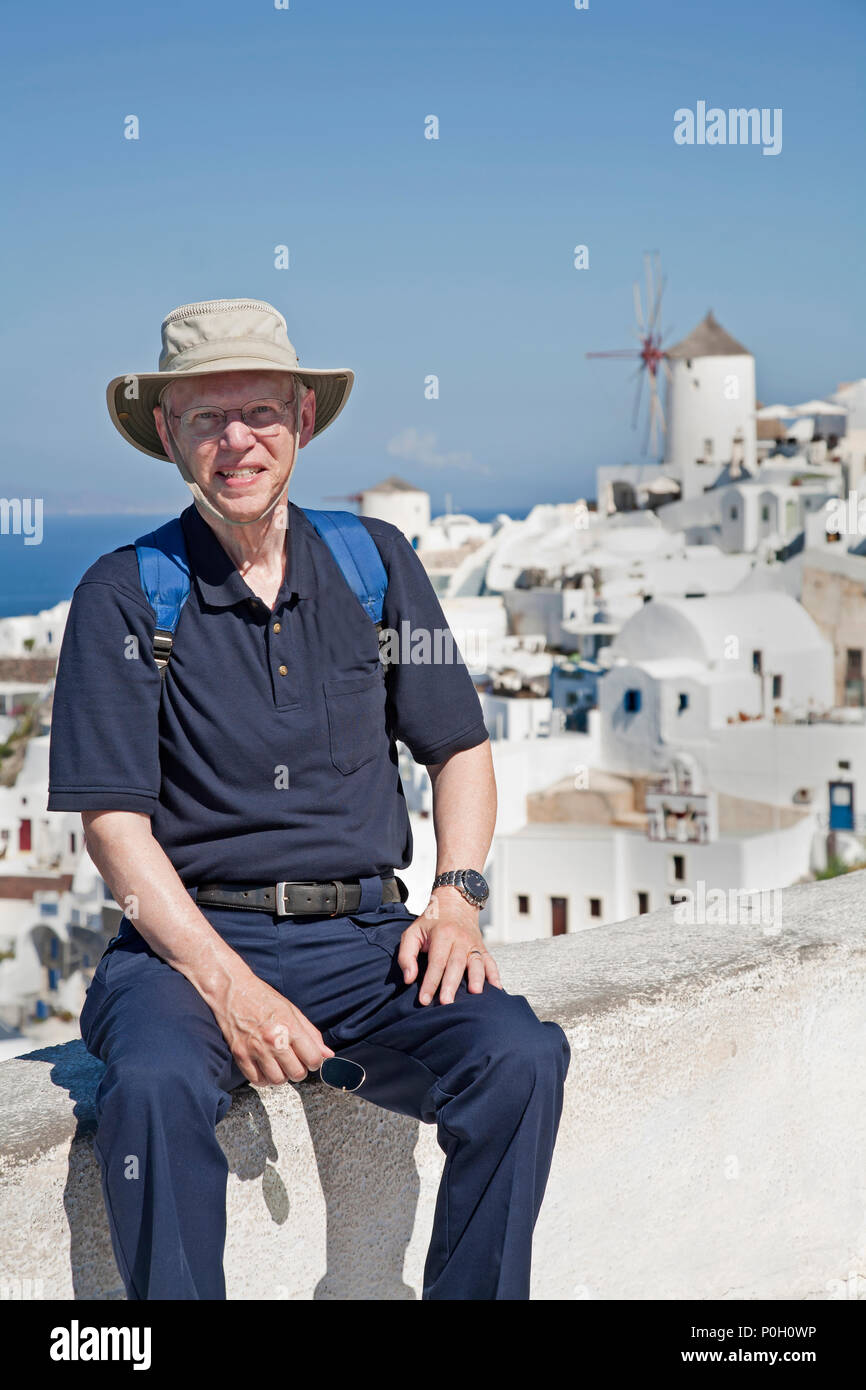 Homme plus âgé avec sac à dos et hat standing à Santorin en Grèce, de sourire et de profiter de services et Banque D'Images