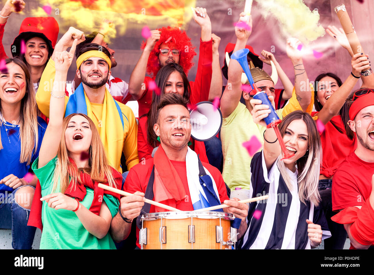 Groupe de fans vêtus de différentes couleurs en regardant un événement ...