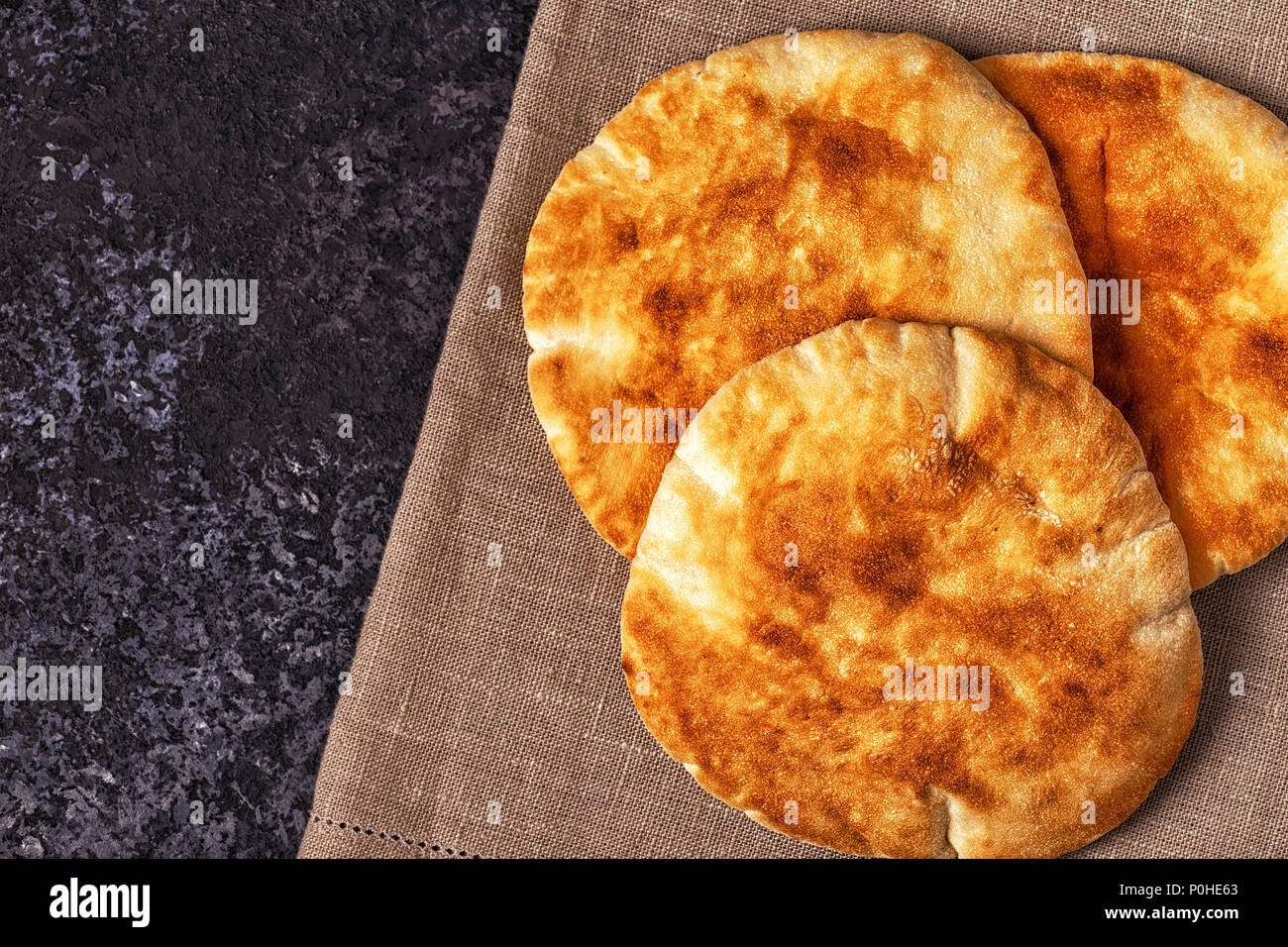 Le pain pita sur un tableau sombre, vue du dessus, copiez l'espace. Banque D'Images