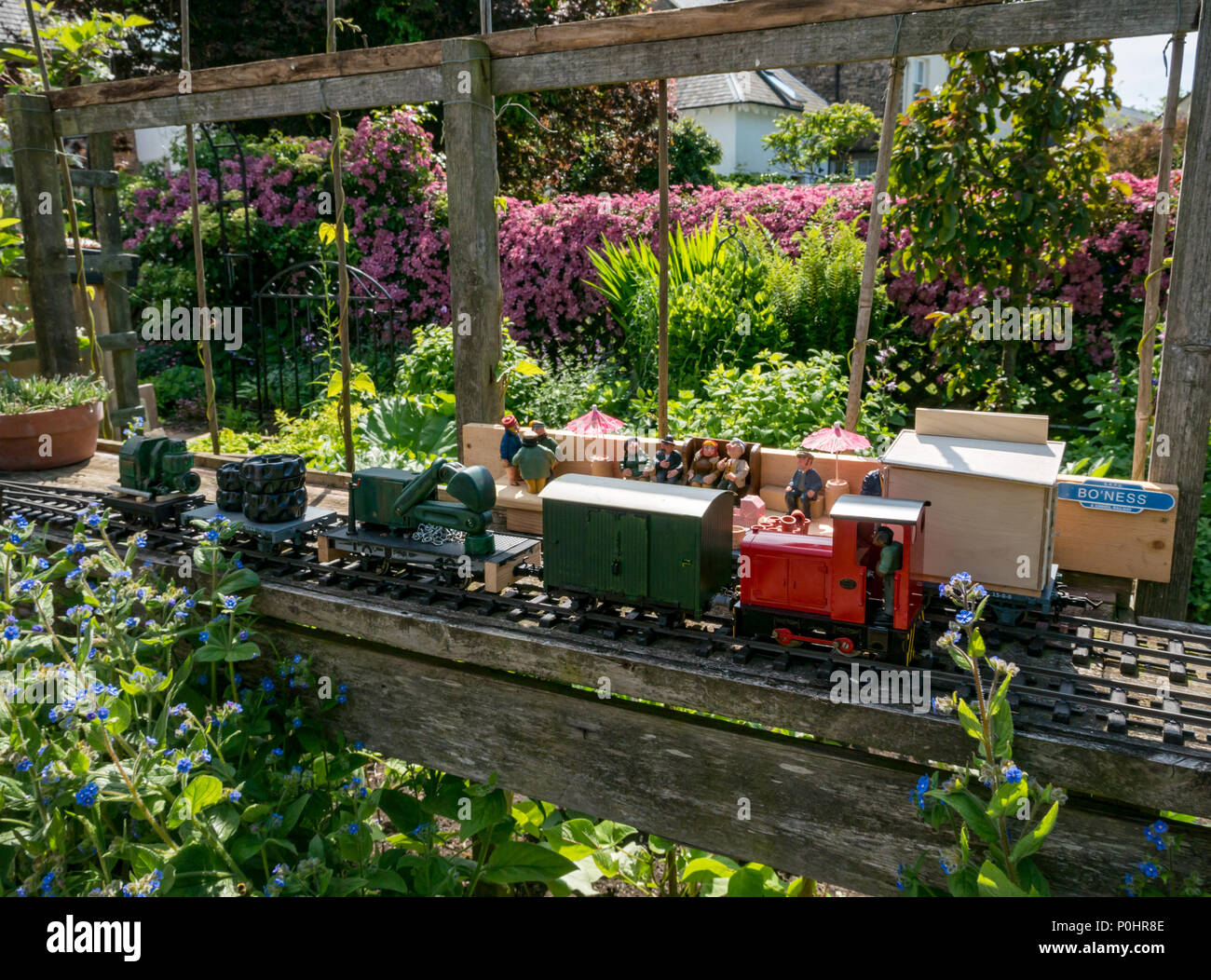 Dirleton Village Gardens, Scotland’s Gardens Scheme 2018, 9 juin 2018. Dirleton Village, East Lothian, Écosse, Royaume-Uni. Les résidents du village ouvrent leurs jardins au public dans le cadre du programme des jardins nationaux. Un modèle de chemin de fer original avec le train modèle, les personnes modèle et la gare dans un jardin par jour ensoleillé Banque D'Images