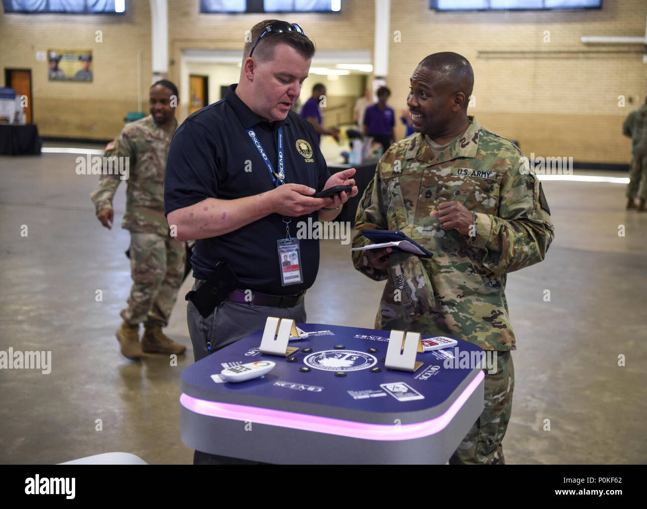 U.S soldats, aviateurs et les employés dans la Garde nationale de Caroline du Sud, assister à la sécurité et santé au travail Fair au bluff Road Armory de Columbia, Caroline du Sud, 1 juin 2018. Derrec Becker, directeur de l'Information et Affaires extérieures en Caroline du Sud, Division de gestion d'urgence démontre la nouvelle protection civile l'app pour smart phone. L'événement vise à sensibiliser sur les questions de sécurité pour promouvoir la santé de l'éducation. (U.S. Photo de la Garde nationale par la CPS. Chelsea Baker) Banque D'Images