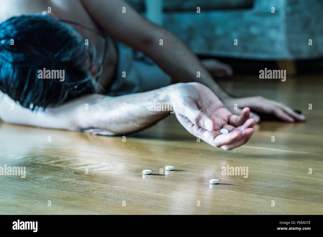 Tentative de suicide concept : allongé sur le plancher à la maison en cas de surdosage après comprimés. Banque D'Images