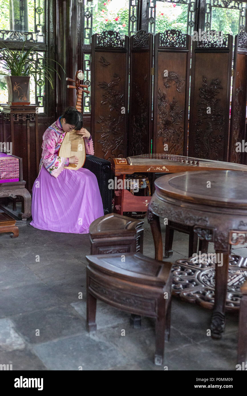Yangzhou, Jiangsu, Chine. Une femme jouant de la PIPA, Famille Ho maison et le jardin. Banque D'Images