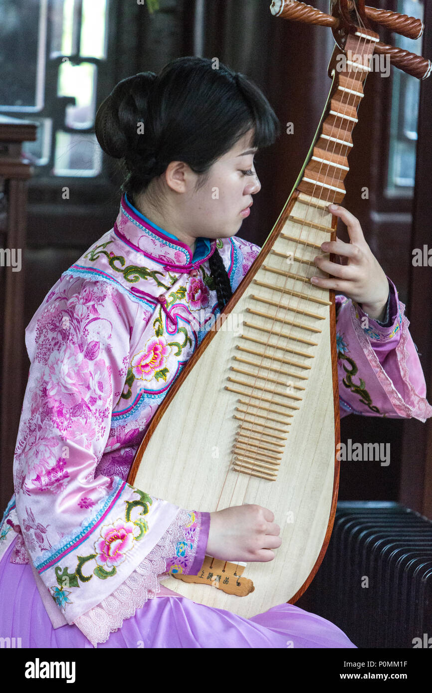 Yangzhou, Jiangsu, Chine. Une femme jouant de la PIPA, Famille Ho maison et le jardin. Banque D'Images