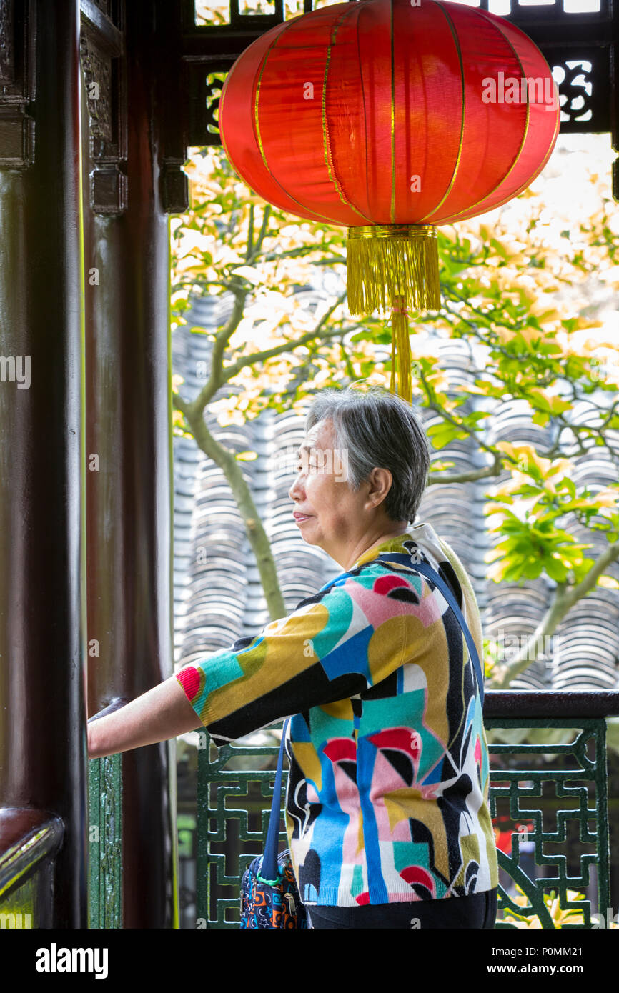 Yangzhou, Jiangsu, Chine. Woman Admiring Cour de la famille Ho Maison et jardin. Banque D'Images