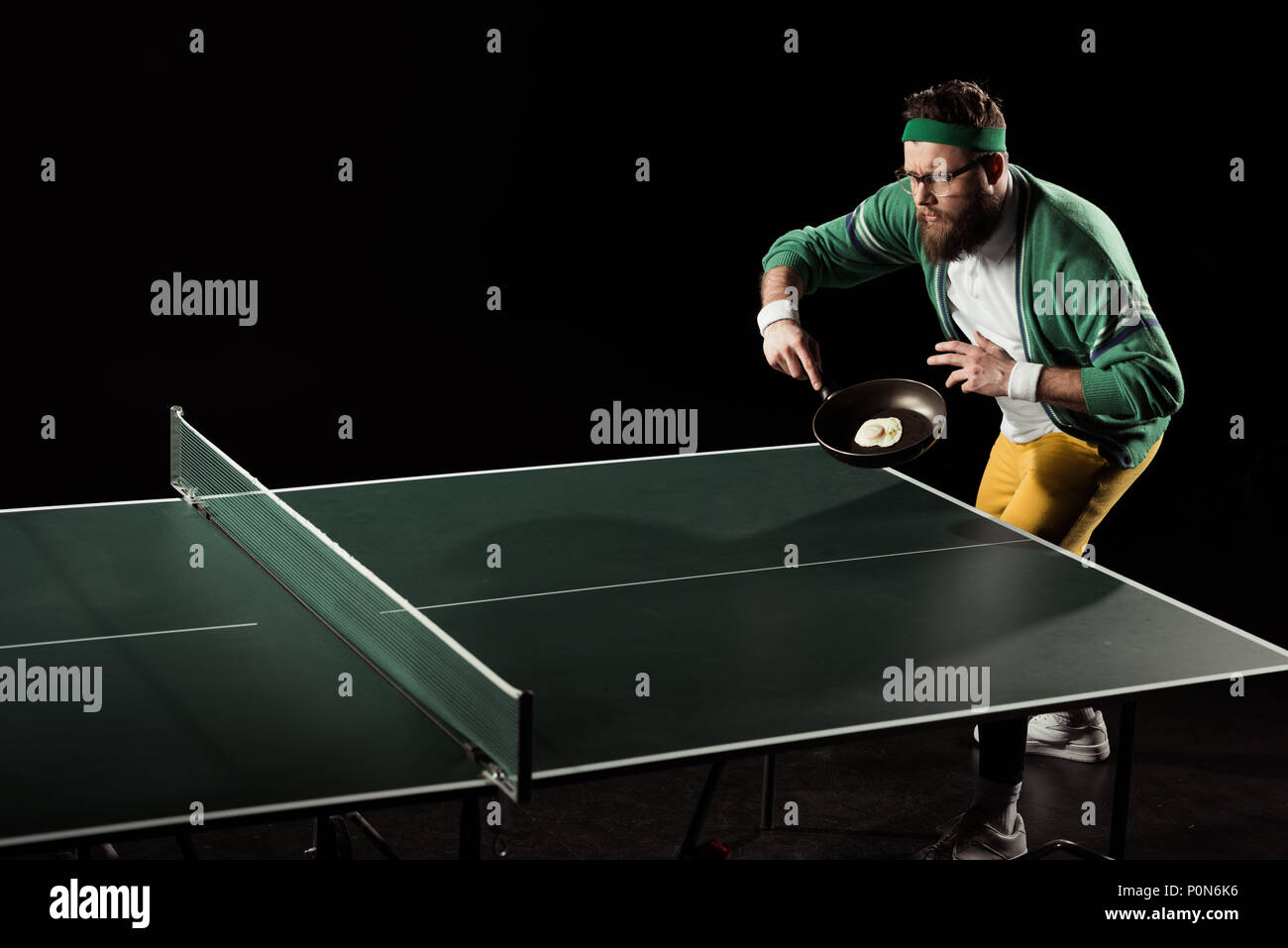 Joueur de tennis avec poêle avec oeuf à jouer au tennis de table isolated  on black Photo Stock - Alamy