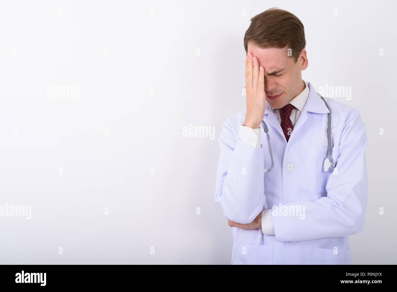 Jeune homme séduisant médecin contre fond blanc Banque D'Images