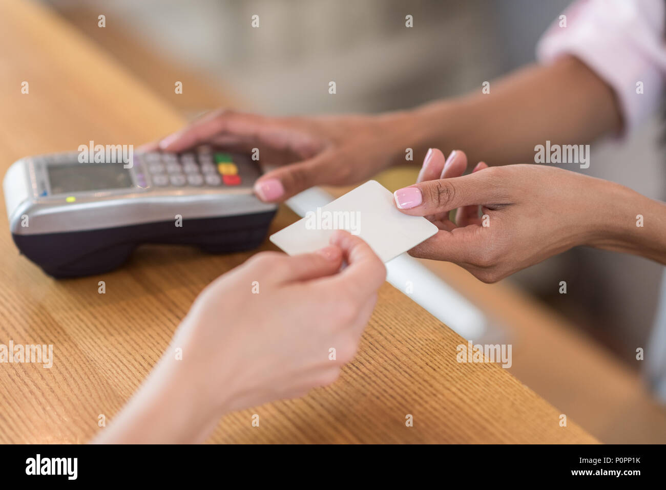 Vue partielle de woman giving credit card de serveuse pour le paiement in cafe Banque D'Images
