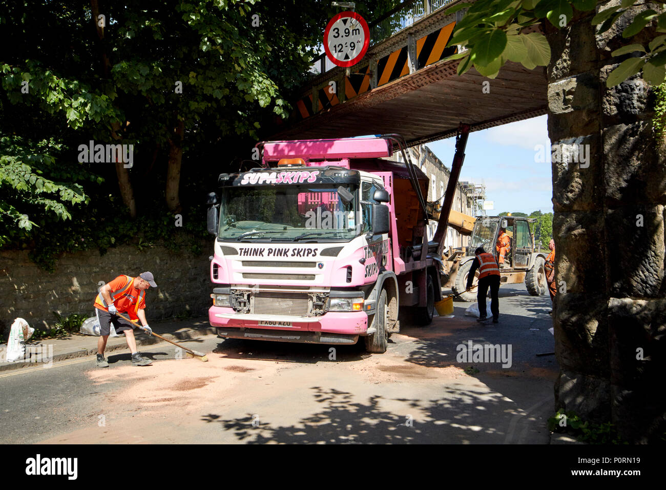 Skip to camion coincé sous un pont faible Lancaster Lancashire England UK Banque D'Images