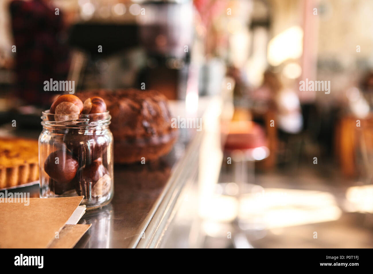 Le compteur dans le café est un arrière-plan flou. Les écrous dans la banque au premier plan, l'intérieur du café dans l'arrière-plan Banque D'Images