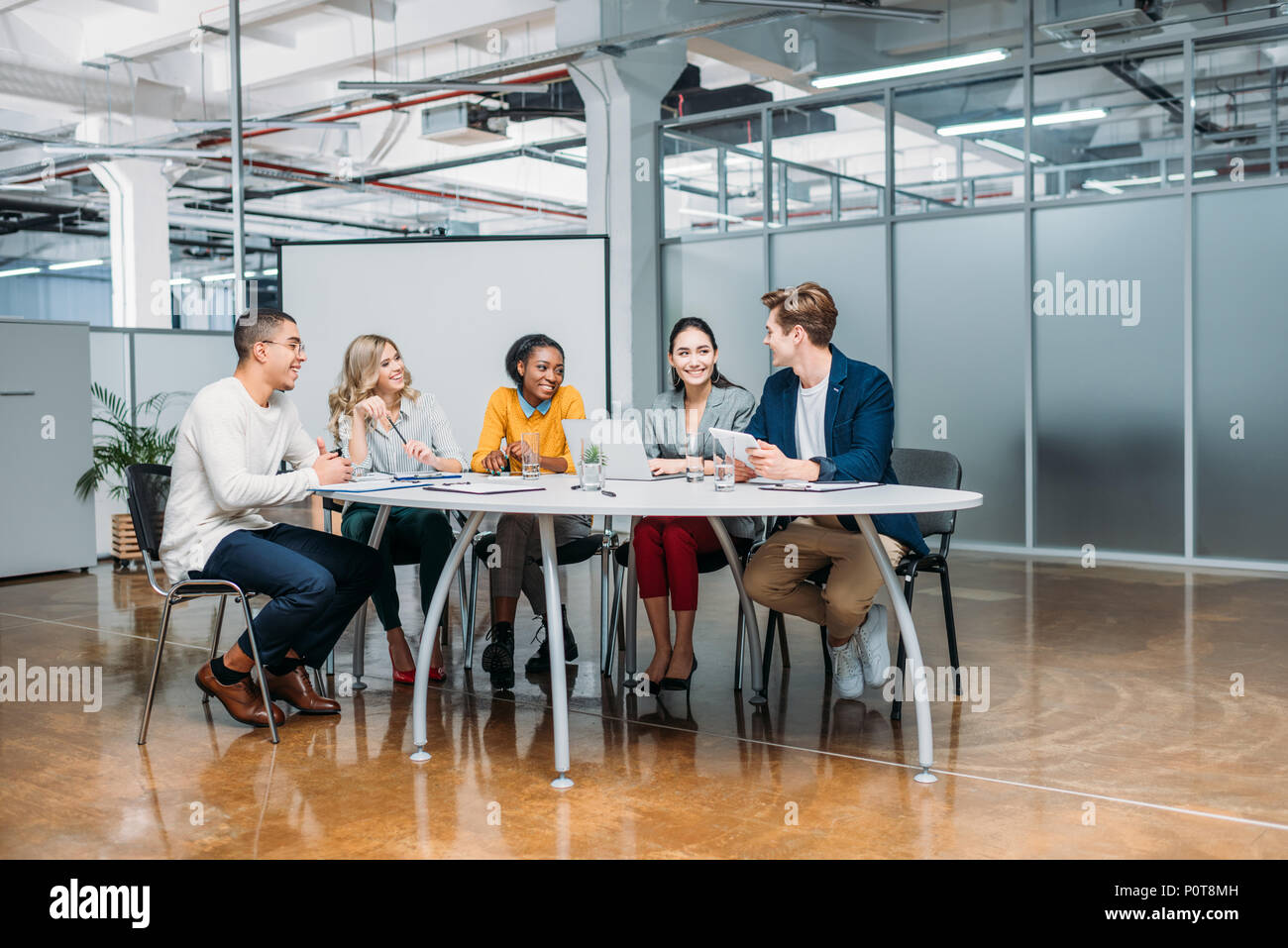 Les jeunes du groupe multiethnique de partenaires d'affaires avoir conversation de bureau moderne Banque D'Images