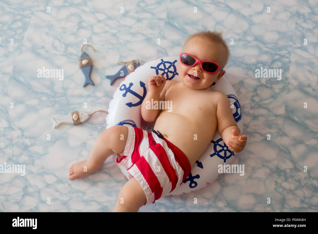 Mignon Bebe Garcon Allonge Sur Un Petit Anneau De Bain Gonflable Portant Des Shorts Et Lunettes De Soleil Maillot De Bain Piscine Shot Photo Stock Alamy