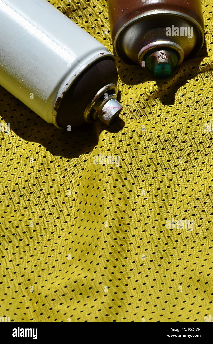 Plusieurs pulvérisateurs de peinture aérosols utilisés se trouvent sur la chemise de sport d'un joueur de basket-ball fait de polyester Tissu. Le concept de l'art de la rue, la jeunesse s'active Banque D'Images