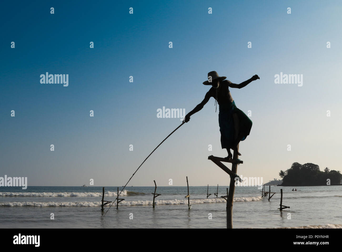 Silhouette du pêcheur traditionnel au lever du soleil près de Galle au Sri Lanka. Banque D'Images
