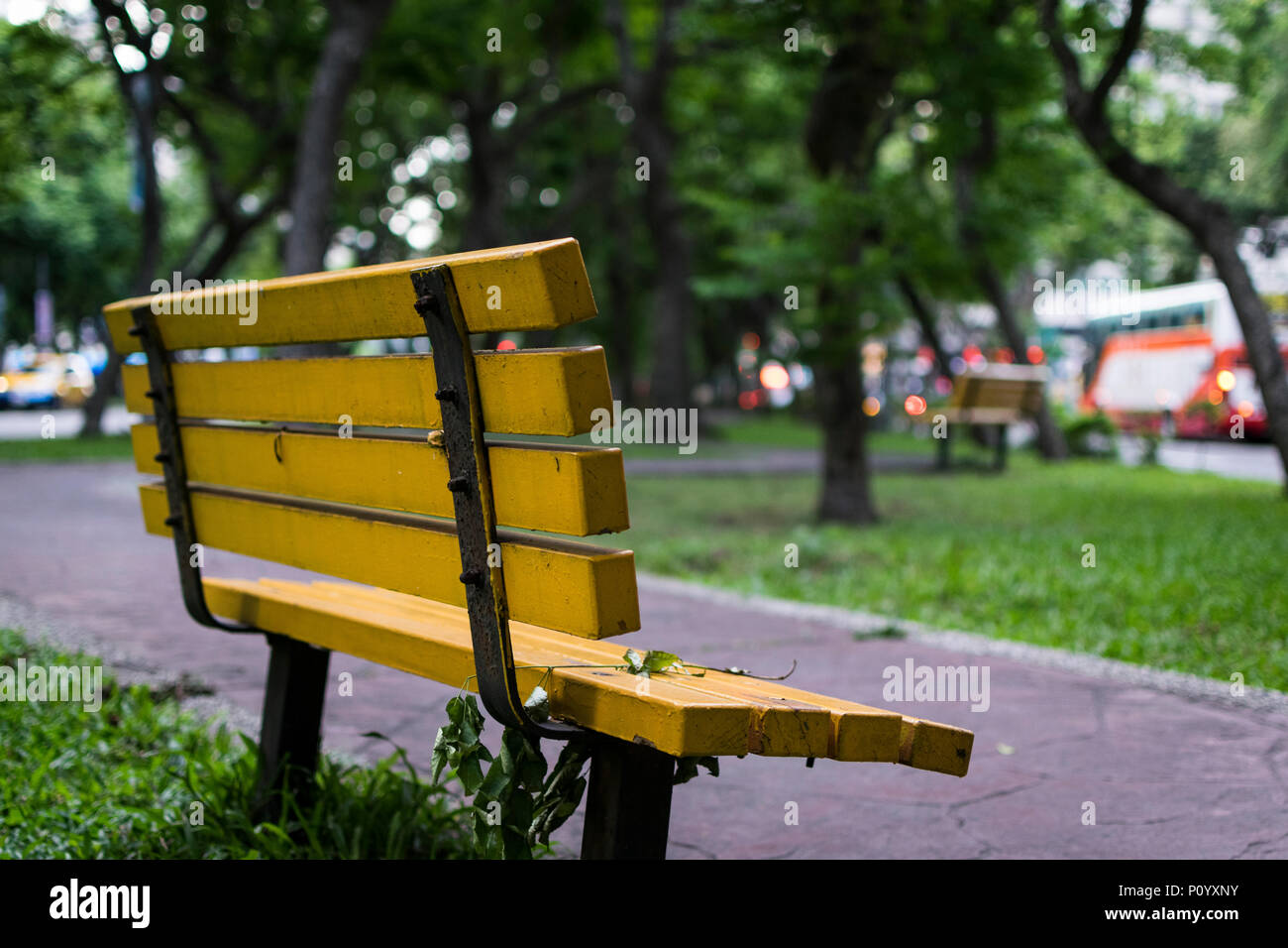 Banc de parc jaune vide à Taipei, juste à côté de voies de circulation du rhône Banque D'Images