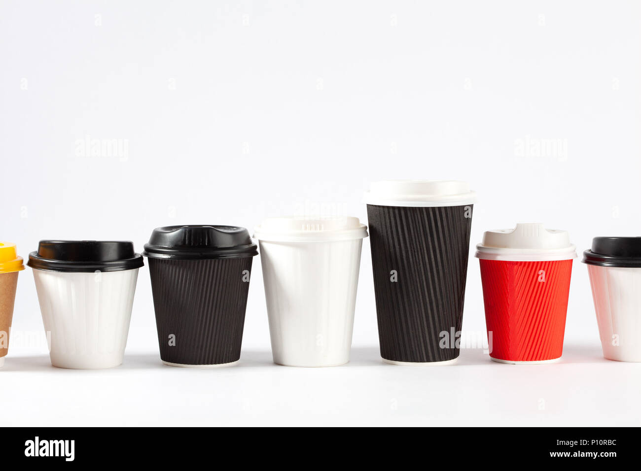 Ligne sans fin de tasses à café jetables de différentes tailles et couleurs sur fond blanc avec copie espace Banque D'Images